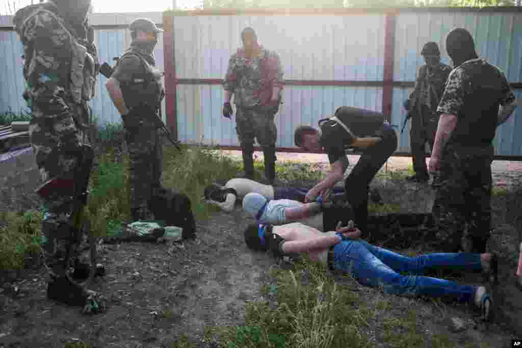 Pro-Russian militants detain three men they suspect of spying for the Ukrainian government in Kramatorsk, eastern Ukraine, May 18, 2014. 