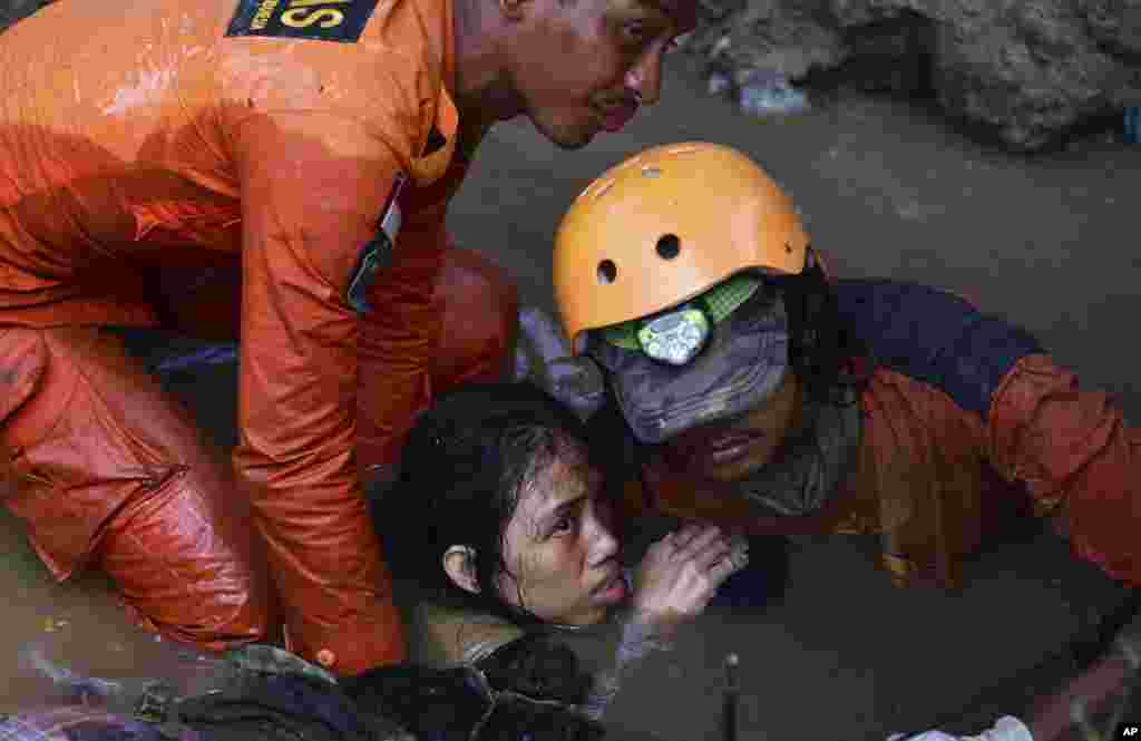 Rescuers evacuate a survivor following earthquakes and tsunami in Palu, Central Sulawesi, Indonesia. Rescuers were scrambling to try to find trapped victims in collapsed buildings where voices could be heard screaming for help after a massive earthquake in Indonesia spawned a deadly tsunami two days ago.