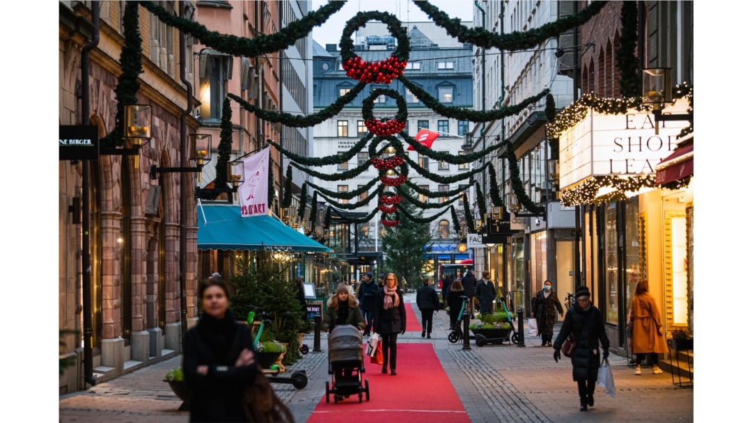 People walk past shops under Christmas decorations during the novel coronavirus pandemic in Stockholm, Dec. 3, 2020.