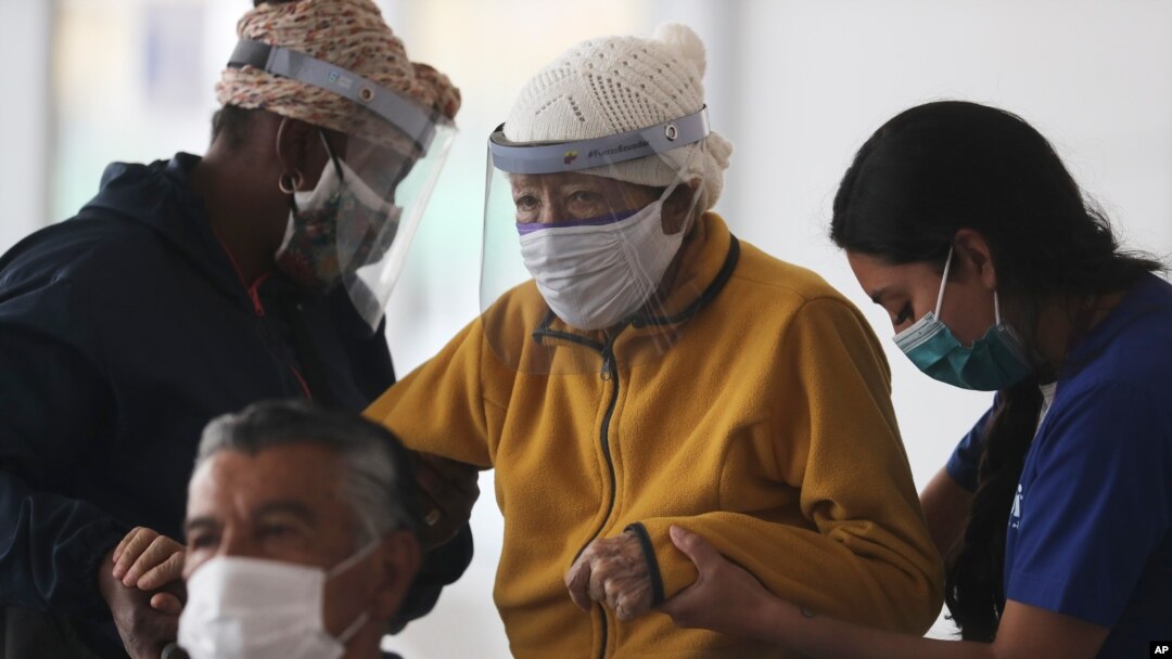 Una anciana es ayudada a subir a un cubículo para recibir una dosis de la vacuna Pfizer COVID-19, en el centro de convenciones convertido en sitio de vacunación, en Quito, Ecuador, el miércoles 31 de marzo de 2021.