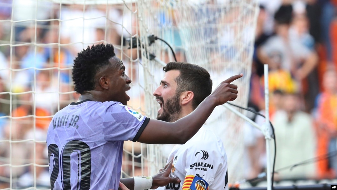 Real Madrid's Vinicius Junior, left, confronts Valencia fans in front of Valencia's Jose Luis Gaya during a Spanish La Liga soccer match between Valencia and Real Madrid, at the Mestalla stadium in Valencia, Spain, Sunday, May 21, 2023.