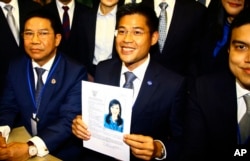 Leader of Thai Raksa Chart party Preecha Pholphongpanich, center, holds a picture of Princess Ubolratana at election commission of Thailand in Bangkok, Feb. 8, 2019.