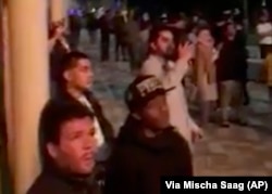 Na ovoj fotografiji, načinjenoj od video snimka koji je obezbedio Miša Sag, ljudi posmatraju zgradu u plamenu u Londonu u sredu, 14. juna 2017.