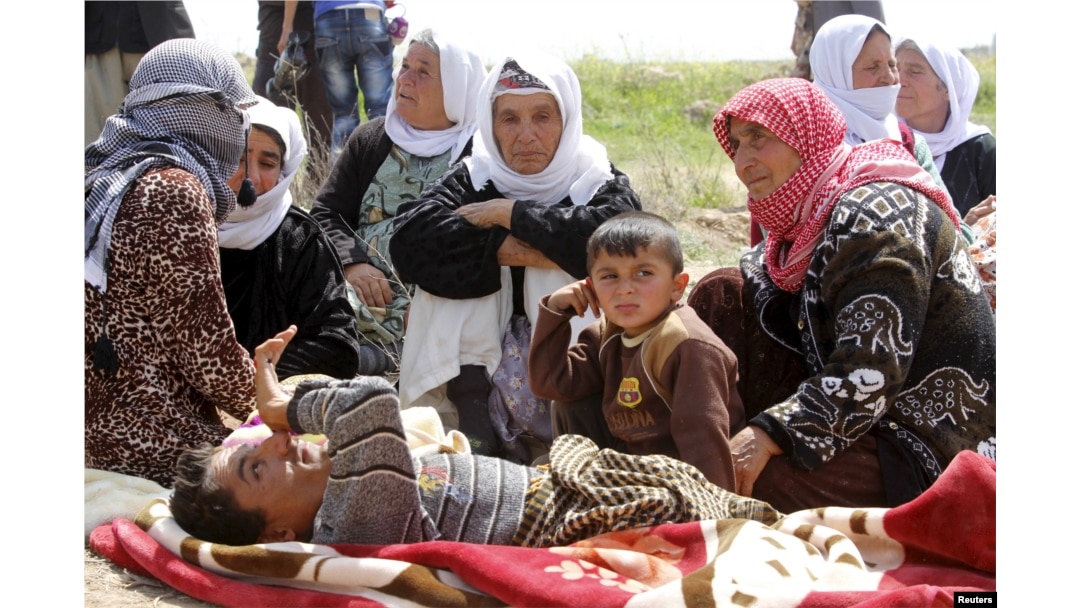 More than 200 Yazidi sect members, freed eight months after they were taken captive by Islamic State militants, wait on the edge of Kirkuk for relocation, April 8, 2015.