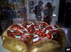 This Nov. 2, 2018 photo shows a textile sculpture from artist Hein Koh called "Mystic Pizza," part of a group art exhibition celebrating pizza at The Museum of Pizza in New York. (AP Photo/Bebeto Matthews)