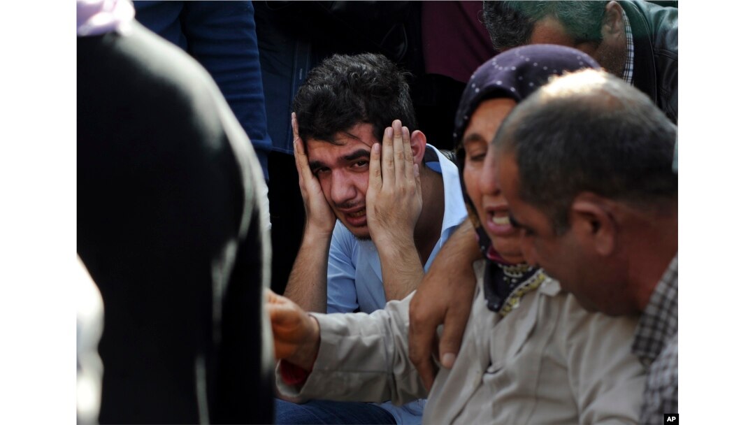 Relatives of people wounded in the explosions in Ankara, react as they wait news for their loved ones outside a hospital, Oct. 10, 2015.
