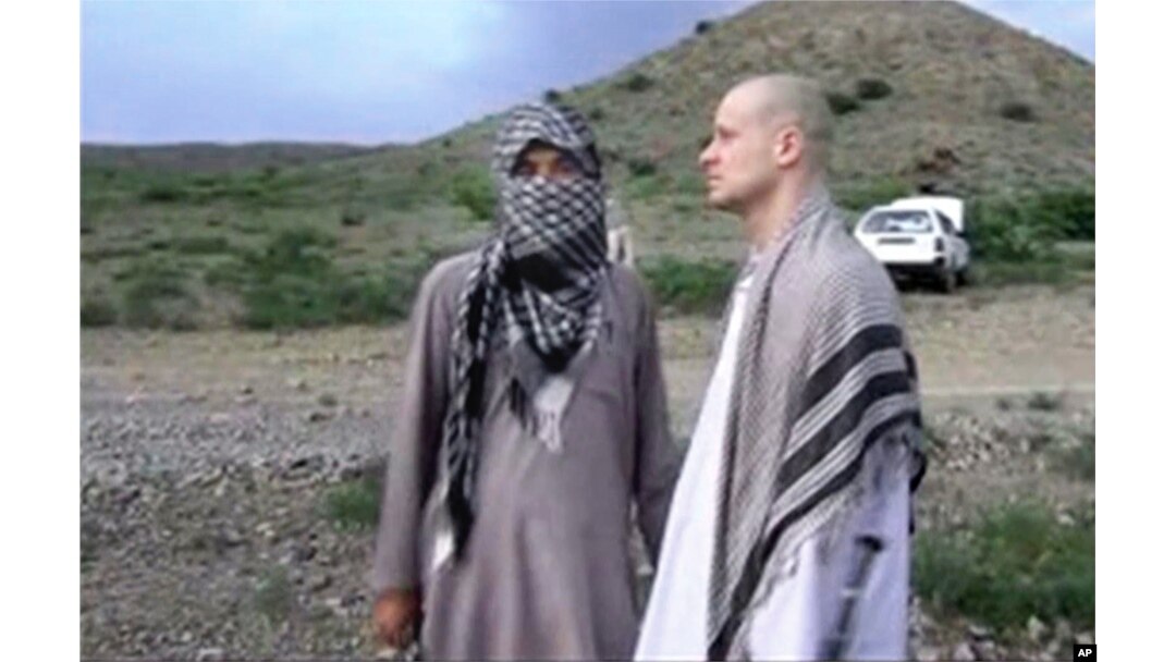 FILE: In this image taken from video obtained from Voice of Jihad website on June 4, 2014, Sgt. Bowe Bergdahl, right, stands with a Taliban fighter in eastern Afghanistan.