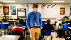 ARCHIVO - Un maestra sustituto en la Escuela Intermedia Greenfield en Greenfield, Indiana, enseña el 10 de diciembre de 2020.