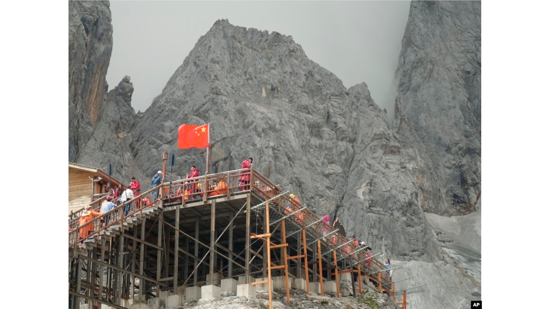 This Sept. 22, 2018 photo shows tourists visiting the Baishui Glacier No.1 atop of the Jade Dragon Snow Mountain in the southern province of Yunnan in China home. Scientists say the glacier is one of the fastest melting glaciers in the world due to climate change and its relative proximity to the Equator. It has lost 60 percent of its mass and shrunk 250 meters since 1982. (AP Photo/Sam McNeil)