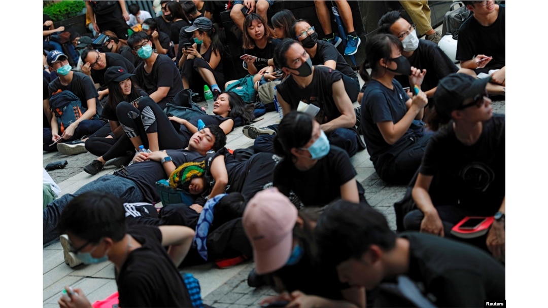 示威者2019年6月21日在香港舉行的示威活動中坐在或躺在地上,他們要求香港領導人下台並撤回引渡法案。