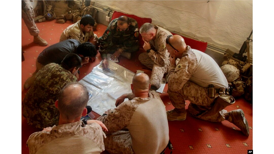 A photo released by Operation Resolute Support headquarters shows U.S. Marines with Task Force Southwest and Afghan National Army soldiers planning for the continuation of offensive combat operations at Camp Hanson, Afghanistan, June 13, 2017.