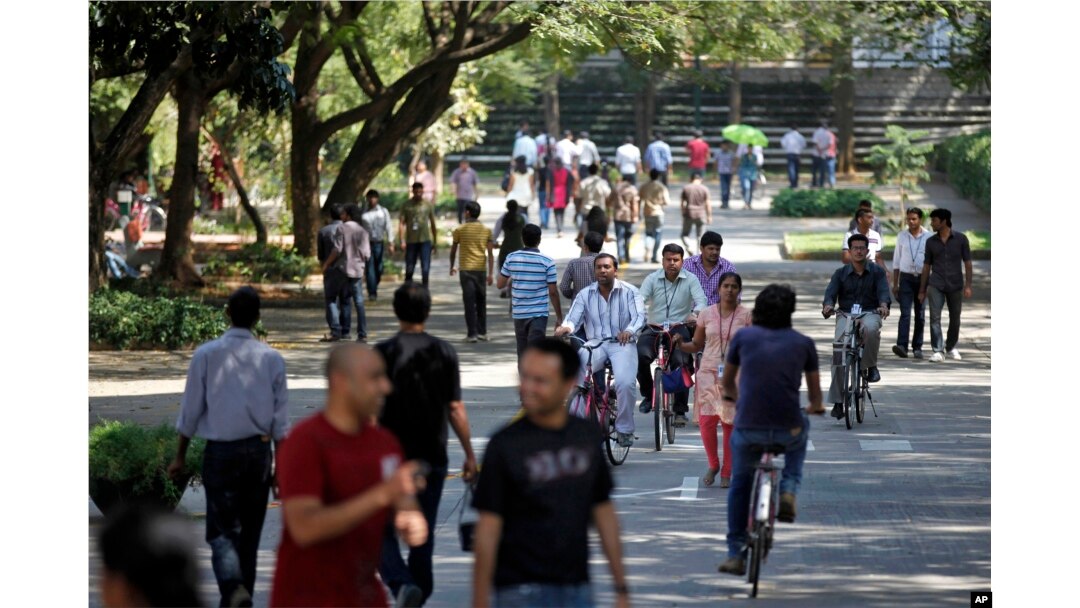 FILE - employees of Infosys Technologies, the Indian technology outsourcing giant, move inside the company headquarters during a break after their quarterly financial results were announced in Bangalore, India.