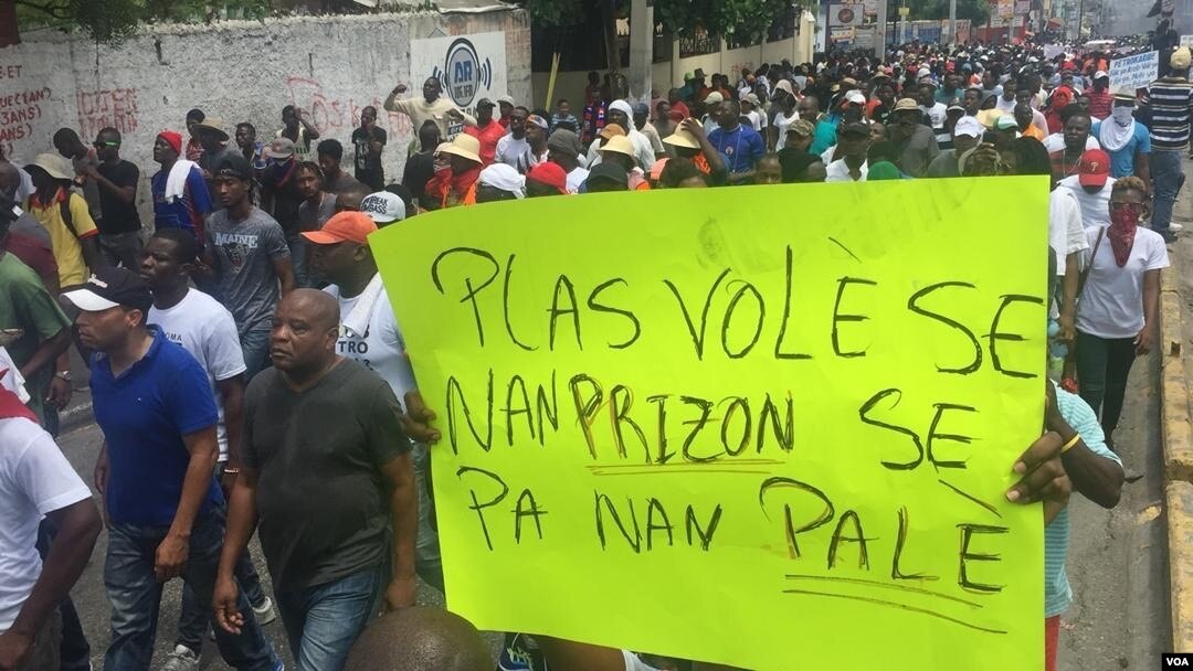 Protester holds poster that reads «Thieves belong in jail, not in the palace» in Port-au-Prince, Haiti, June 9, 2019. (Matiado Vilme, VOA Créole)