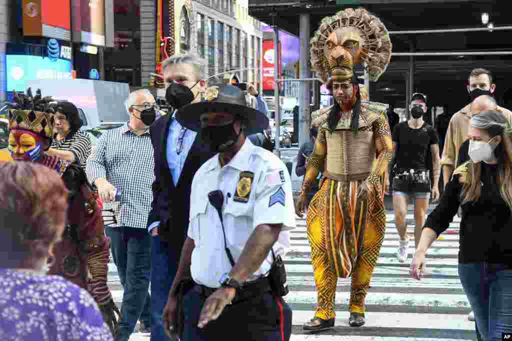 Costumed cast members of Broadway's "The Lion King," L. Steven Taylor, as Mufasa, right, and and Tshidi Manye, as Rafiki, left, appear in Times Square to herald the return of Broadway theater in New York.