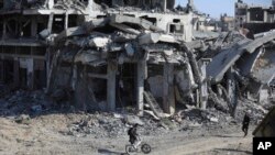 Palestinos caminan en medio de la destrucción dejada por ofensiva terrestre y aérea israelí tras su retirada de Khan Yunis, en el sur de la Franja de Gaza, el domingo 7 de abril de 2024. 