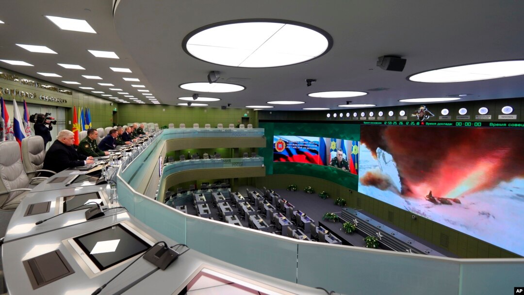 FILE - Russian President Vladimir Putin, fifth left, and other top officials oversee the test launch of the Avangard hypersonic missile from the Defense Ministry's control room in Moscow, Dec. 26, 2018. 