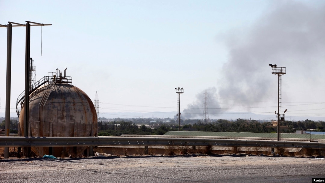 Smoke rises near oil tanks after heavy fighting between rival militias broke out near the airport in Tripoli, July 23, 2014. 