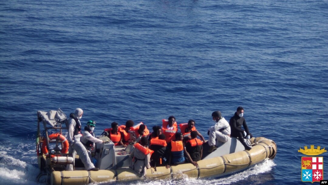 This handout picture released by the Italian Navy on June 6, 2014 shows migrants on boats being arrested and rescued by the Italian army off the coast of Sicily. The Italian navy on June 6 said it had rescued around 2,500 asylum-seekers in the Mediterranean.