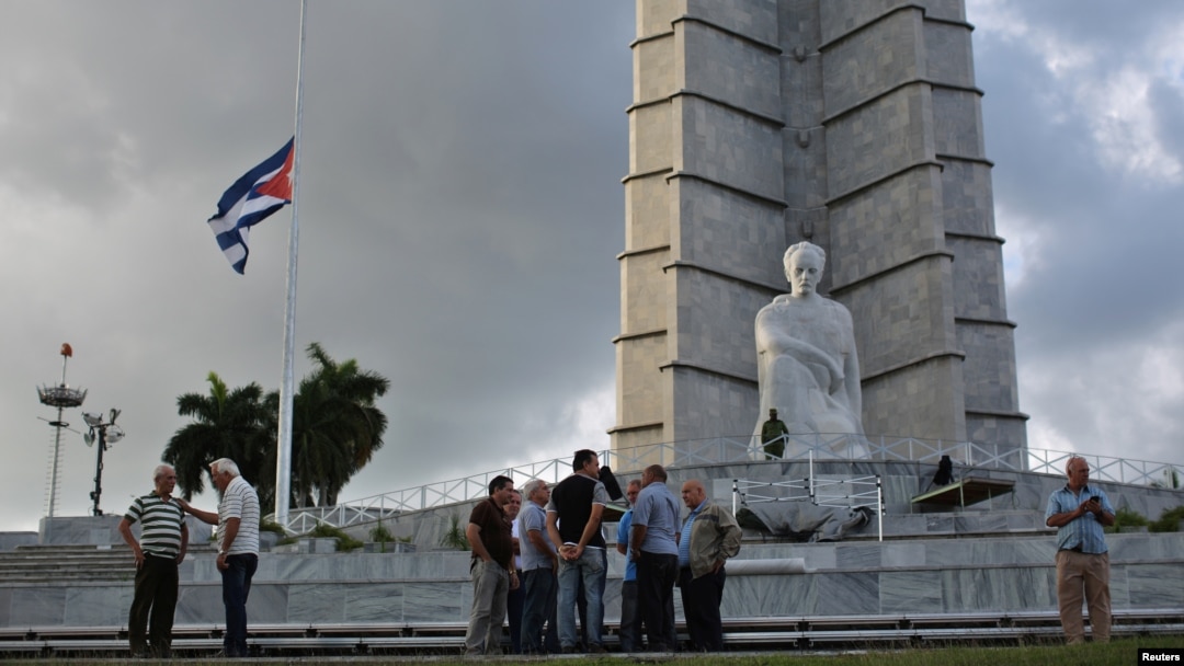 A Cuban flag flies at half-staff at Revolution Square as people gather following the announcement of the death of Cuban revolutionary leader Fidel Castro, in Havana, Cuba, Nov. 27, 2016. 