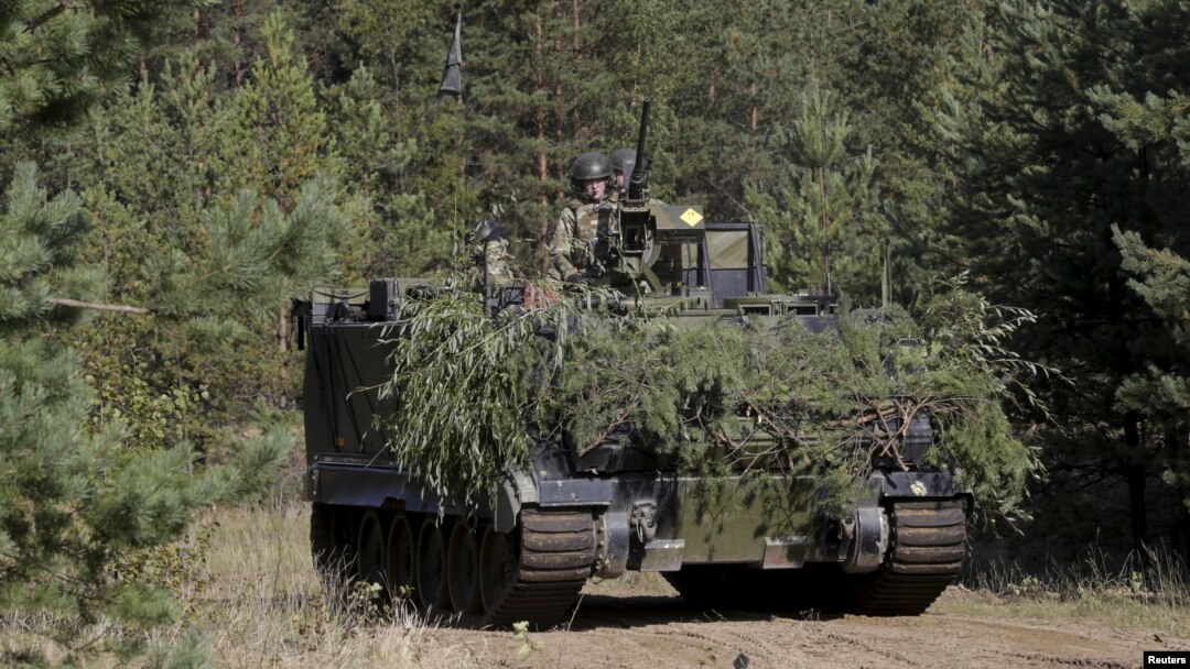 FILE - Danish troops with M113 armored personnel carrier take part in a live fire exercise in a tactical environment ahead of the "Silver Arrow" drill in Adazi training field, Latvia, Sept. 5, 2015. Israel has informed the United States that Lebanese Hezbollah fighters in Syria are using U.S. armored personnel carriers originally supplied to the Lebanese Army.