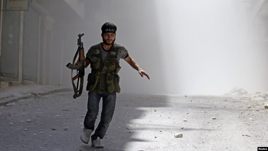 A Free Syrian Army fighter runs after a Syrian Army tank shell explodes in the Salah al- Din neighbourhood of central Aleppo, August 5, 2012.