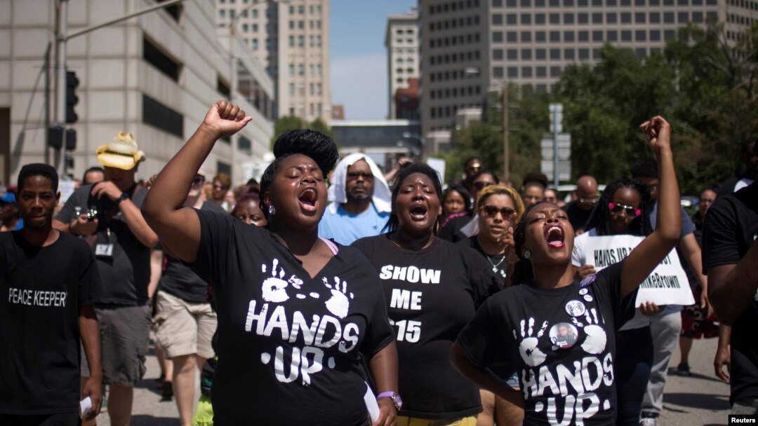 Activists raise their hands as they demand justice for the killing of Michael Brown while marching to the Thomas F. Eagleton United States Courthouse from City Hall in downtown St. Louis, Missouri, Aug. 26, 2014. 