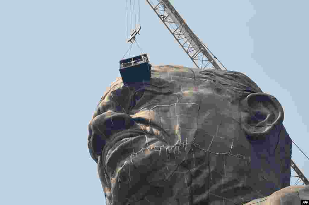 Indian workers give the finishing touches to the world's tallest statue dedicated to Indian independence leader Sardar Vallabhbhai Patel. The statue overlooks the Sardar Sarovar Dam near Vadodara, in India's western Gujarat state.