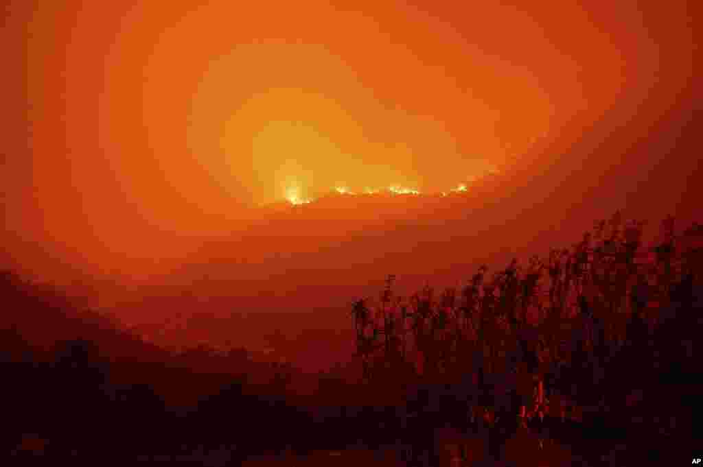 Flames from the KNP Complex Fire burn along a hillside above the Kaweah River in Sequoia National Park, California, Sept. 14, 2021.