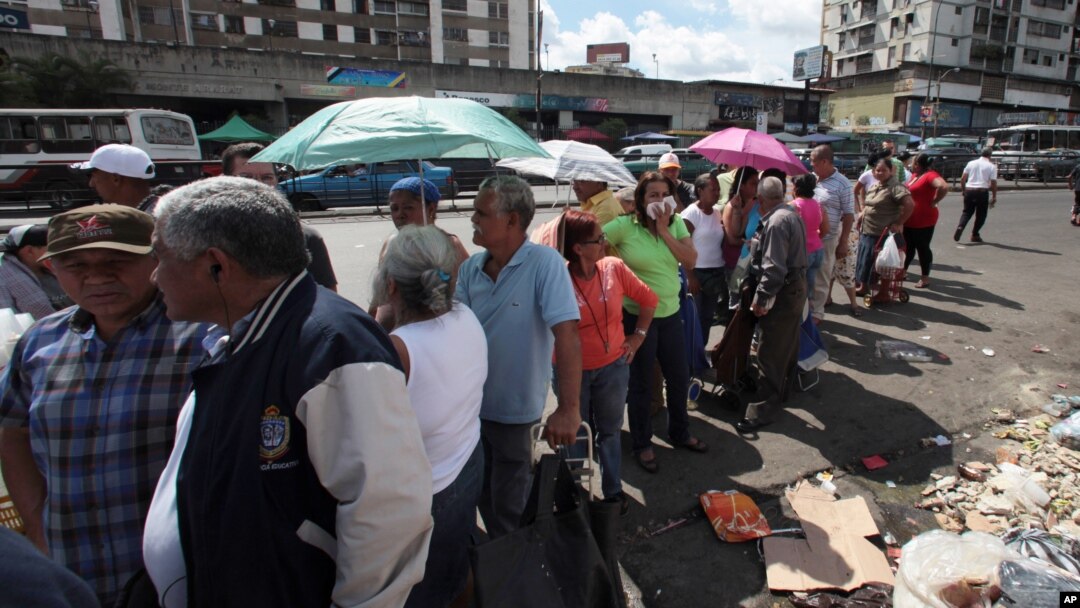 El gobierno del presidente Maduro asegura que las colas en los comercios son parte de una campaña en su contra.