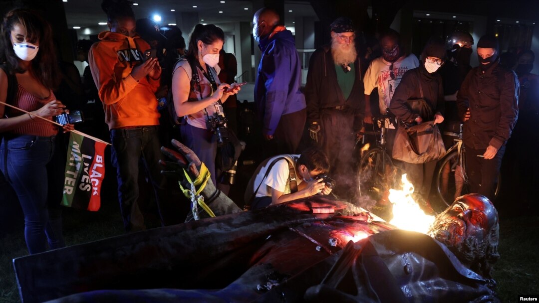 Periodista fotografía estatua derribada de Albert Pike en llamas durante un evento para conmemorar el 16 de junio, que conmemor el fin de la esclavitud en Texas, durante protestas por la desigualdad racial en Washington, el 19 de junio de 2020. 