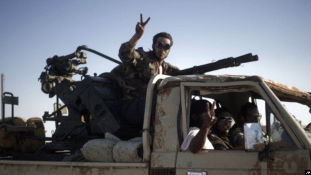 Libyan rebels drive a vehicle mounted with an anti-aircraft gun toward Bin Jawad, August 26, 2011