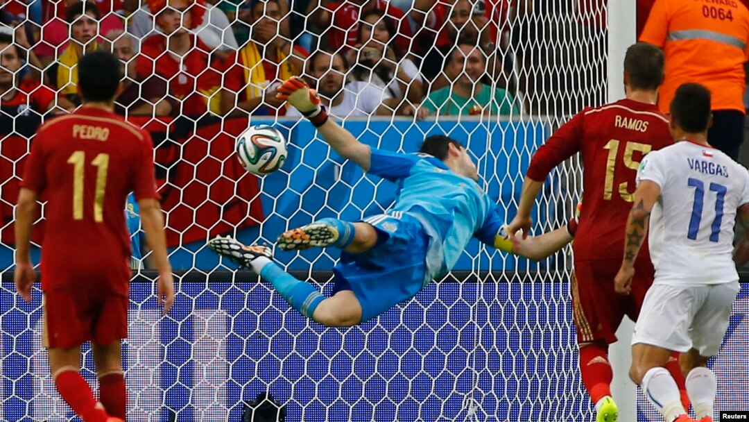 Spain's goalkeeper Iker Casillas dives trying to save a ball from Chile's Charles Aranguiz (not pictured) during their 2014 World Cup Group B soccer match at the Maracana stadium in Rio de Janeiro, June 18, 2014.
