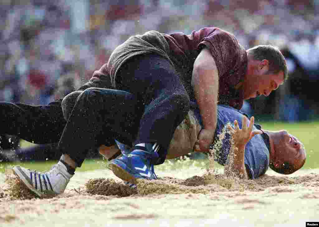 Swiss Alpine wrestlers Christian Stucki (top) fights with Martin Koch during the Federal Alpine Wrestling Festival in Burgdorf. Swiss Alpine wrestling, called "Schwingen", is the oldest sport in Switzerland. 