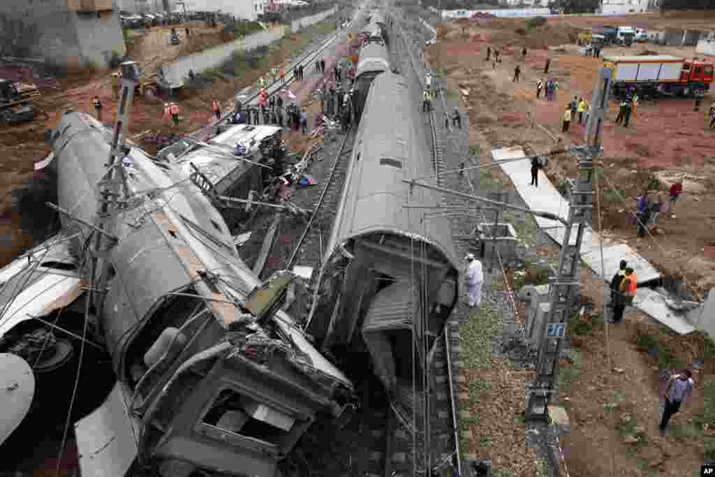 People gather after train derailed near Sidi Bouknadel, Morocco. A shuttle train linking the Moroccan capital Rabat to a town further north on the Atlantic coast derailed, killing several people and injuring dozens, authorities and the state news agency said.