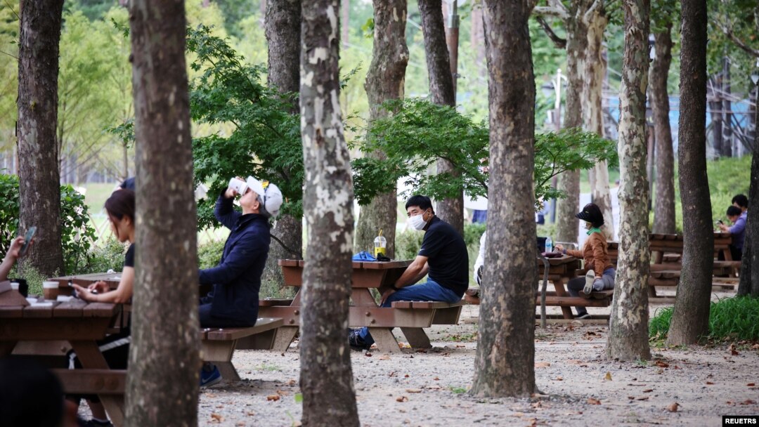 지난달 한국의 서울 시내 공원에서 시민들이 사회적 거리두기를 지키며 휴식하고 있다. 