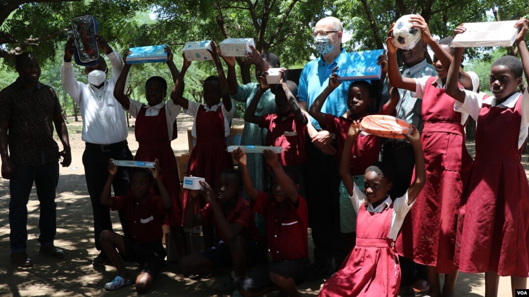 Students at Sekeni Primary School in Chikwawa district hold up educational materials and other supplies they received from UNICEF. (Lameck Masina/VOA)