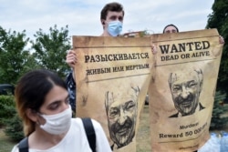Opposition supporters hold up "Wanted" posters with images of Belarusian President Alexander Lukashenko during protests over the country's disputed presidential election, in Minsk, Aug. 18, 2020.