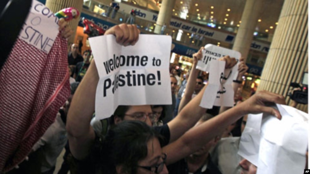 Pro-Palestinian Israeli activists hold signs during a small demonstration at the arrival terminal at Ben Gurion International Airport near Tel Aviv in support of a "fly-in" by other pro-Palestinian activists to Tel Aviv over the weekend, July 8, 2011