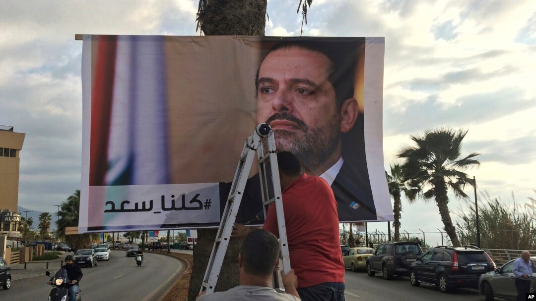 Workers hang a poster of Prime Minister Saad Hariri with Arabic words that read "We are all Saad," on a seaside street in Beirut, Lebanon, Nov. 9, 2017. 