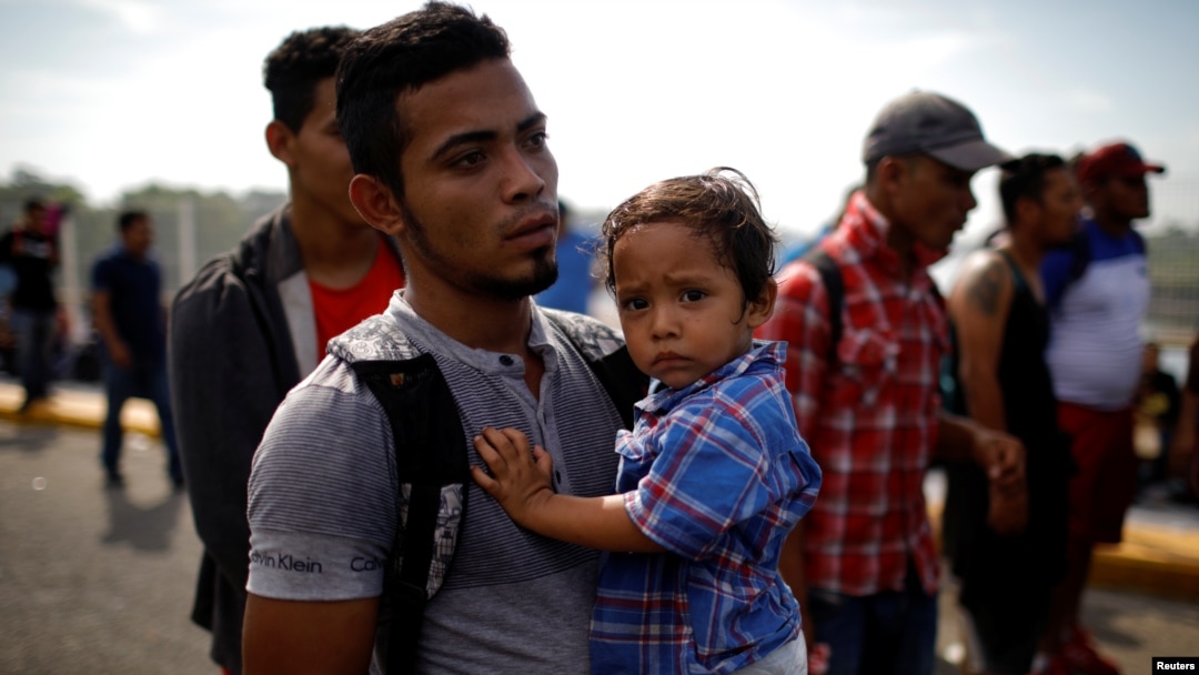 Un migrante salvadoreño carga a su hizo en territorio de Guatemala camino hacia Estados Unidos el 18 de enero de 2020.