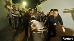 Palestinians wheel the body of a militant at a hospital, following an Israeli air strike in the northern Gaza Strip October 13, 2012.
