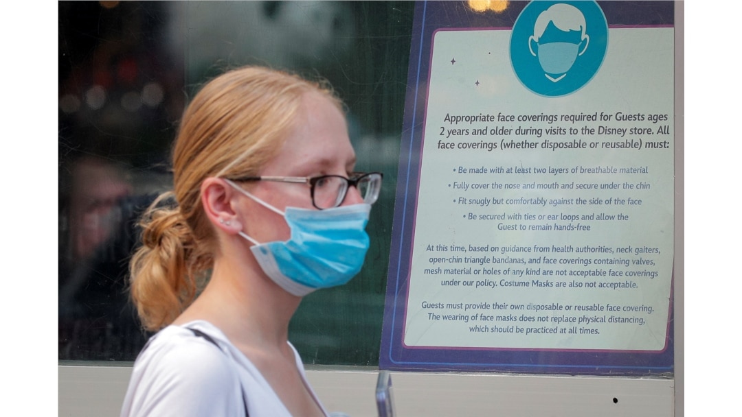 FILE - A woman wears a mask against COVID-19, following the CDC's recommendation that even fully vaccinated Americans wear masks to limit the spread of the highly transmissible coronavirus delta variant, in New York City, July 27, 2021.