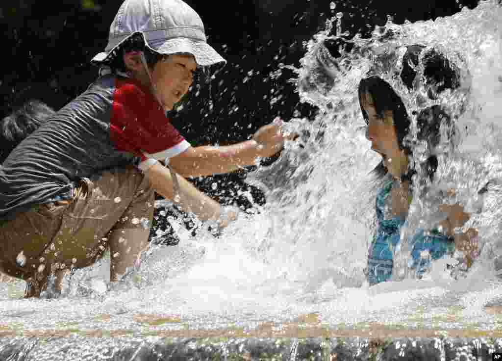 Children play in the water fountain at Asuka park in Tokyo, Japan.