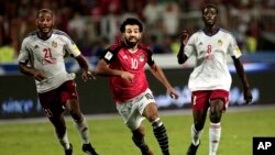 FILE - Egypt's Mohamed Salah, center, battles for the ball with Congo's Delvin N'Dinga, right, and Tobias Badila during the 2018 World Cup group E qualifying soccer match at the Borg El Arab Stadium in Alexandria, Egypt, Oct. 8, 2017. 