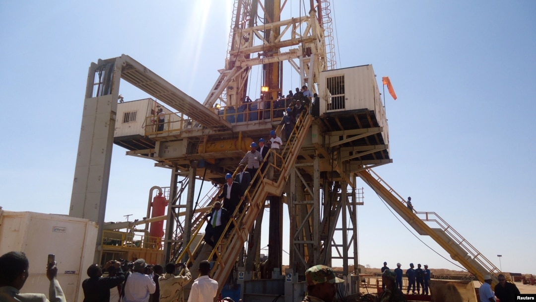 FILE - Engineers and visitors view an exploratory well near Dharoor town, from the port of Bosasso on the Gulf of Aden in Puntland, Somalia, Jan. 17, 2012.