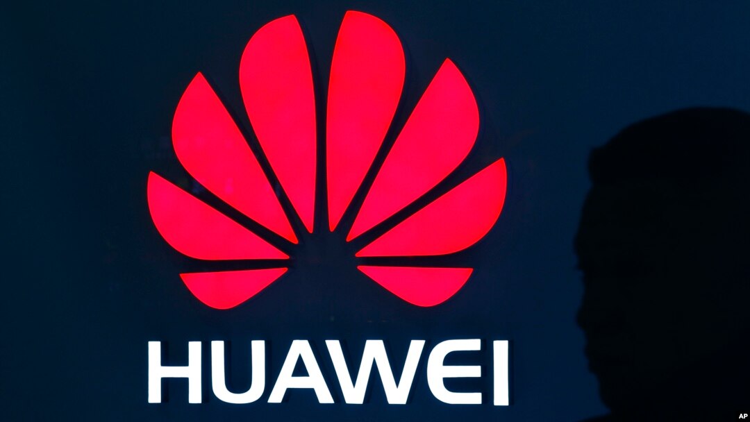 A man is silhouetted as he walks by a Huawei retail store at a shopping mall in Beijing, China, Dec. 11, 2018.
