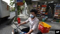 Grocery delivery man Saeed Vatanparast, wearing a face mask to protect against the coronavirus, leaves on his motorcycle for a delivery, in Tehran, Iran, April 21, 2020.