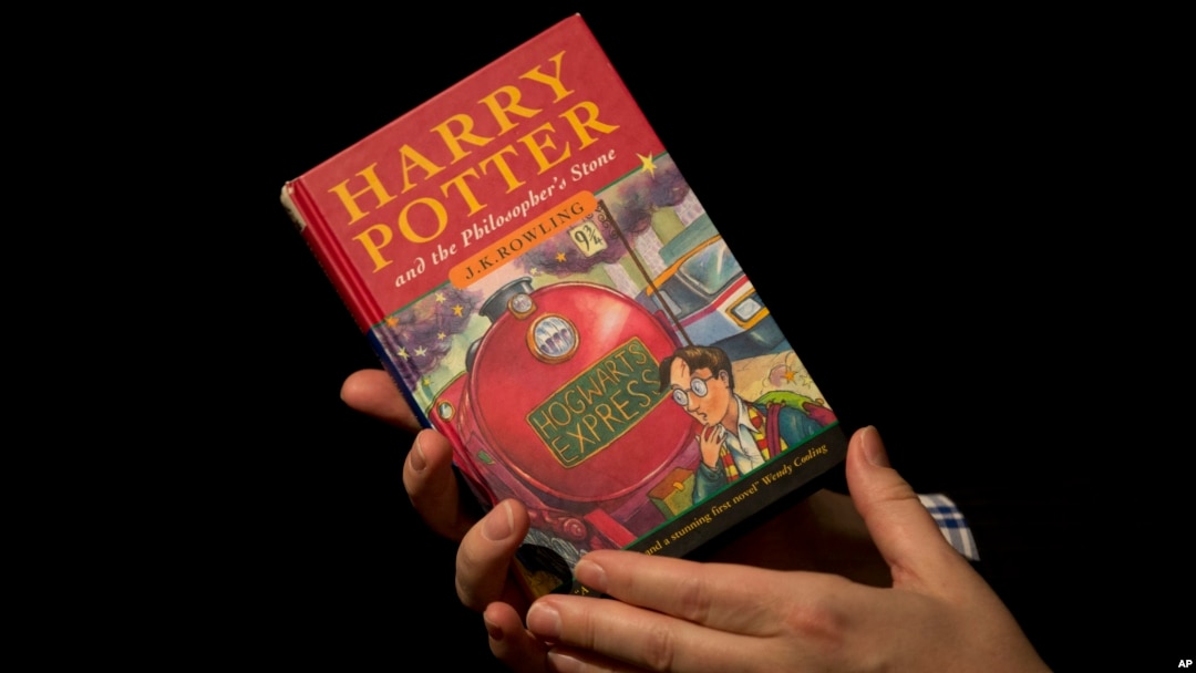 FILE - Sotheby's director of the department of printed books and manuscripts holds a first edition copy of the first Harry Potter book "Harry Potter and the Philosopher's Stone" containing annotations and illustrations by author J.K. Rowling, May 20, 2013.