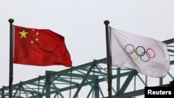 中國國旗和奧運旗幟在北京冬奧組委會外飄揚。 （2021年3月30日）