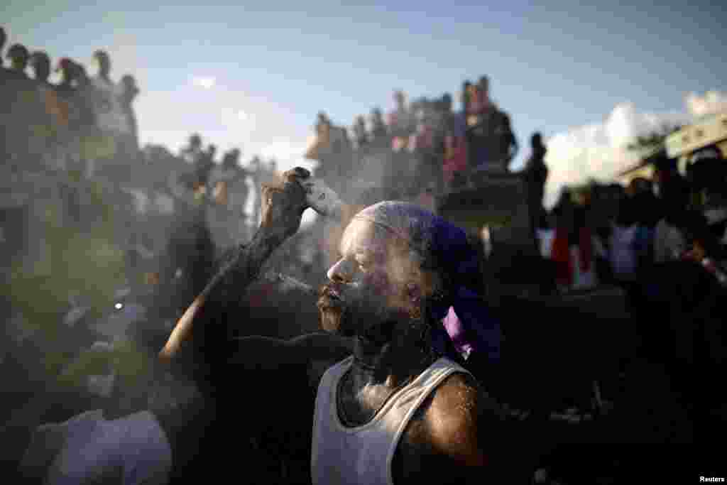 A Voodoo believer covers his face with baby powder during celebrations in a cemetery in Port-au-Prince, Haiti, Nov. 1, 2018.